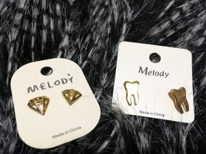 A picture of two sets of gold earrings: one that is in the shape of diamonds and the other in the shape of teeth