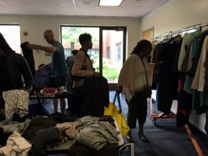 A picture of the DCGF Swap attendees looking through the items that are being swapped. Most of the items are clothing and are placed on tables.