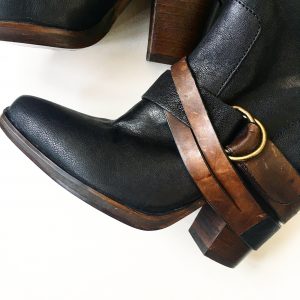 A picture of a pair of Steve Madden high boots with brown leather straps and buckles (a close up of the straps and buckles