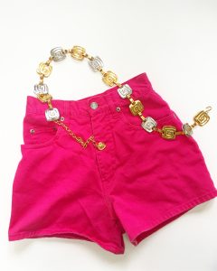 A picture of hot pink shorts with a gold and silver belt