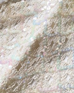 A close up of the sequins on the cream sleeveless shirt