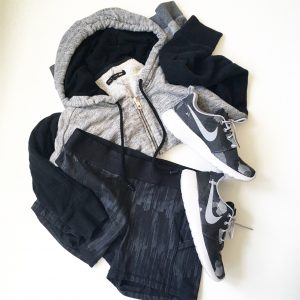 A picture of three items: a size medium, comfy, soft gray and black, paneled hoodie by Rag and Boone, stretchy, elastic, black Lululemon fitness mini running shorts in a size 8, and a pair of Nike, grey, black, and white monochromatic running shoes