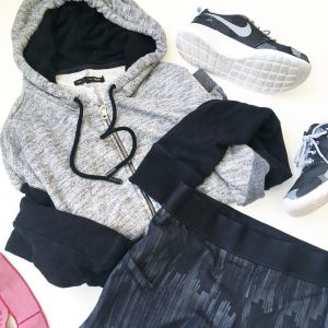 A picture of four items: a size medium, comfy, soft gray and black, paneled hoodie by Rag and Boone, stretchy, elastic, black Lululemon fitness mini running shorts in a size 8, a pair of Nike, grey, black, and white monochromatic running shoes, and a pink headband