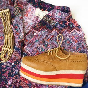 A picture of the top of a pattern-mixing, artistic, party button-down by designer Nicole Miller Atelier in a size medium, multi-colored, platformed, oxford cut shoes, and a five cord gold necklace