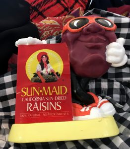 A picture of a 1980's Sun Maid raisin bank with a raisin character in sunglasses on it