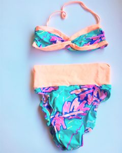 A high waisted, 90's style, turquoise, purple, and light orange bikini