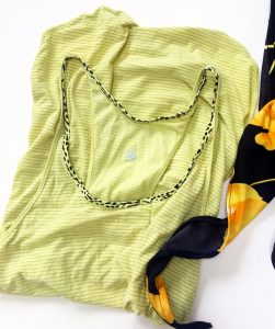 Lululemon striped yellow tank top with a yellow and black leopard print lining around the collar. It is folded in half