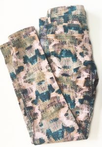 A pair of patterned Madwell pants. The pattern looks painted on and has the colors blue, pink, black, olive green, and a light peach color