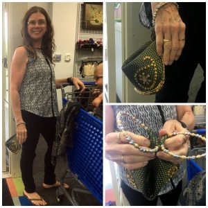 A collage of three pictures: the larger one on the left is of a woman in glasses, a sleeveless shirt, and black pants standing next to a blue shopping cart with a baby in it holding a small ornate clutch. The picture on the top right is a close up of the ornate, green clutch with gold beads and a silver and gold handle and the picture on the bottom right is a closer look at the clutches' handle