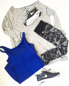 A picture of various items: black Nike workout sneakers, black and gray camo patterned workout pants, granite gray, Free People long sleeve top, and ultramarine blue and black striped, sleeveless, Lululemon workout top