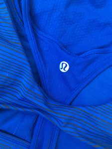 The back of an ultramarine blue and black striped, sleeveless, Lululemon workout top