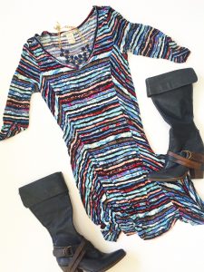 A picture of a high-low dress with watercolors like pink, blue, purple and black print in a size large. Also pictured are a pair of tall, black, leather boots