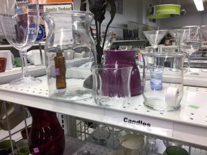 A picture of various glassware on a shelf at a Goodwill store.