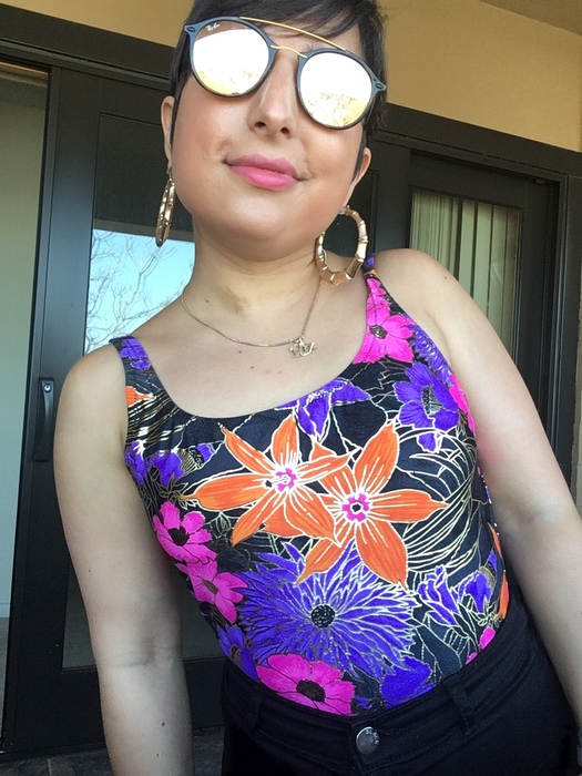Carolyn pairs a bold, floral swimsuit from Goodwill with black shorts