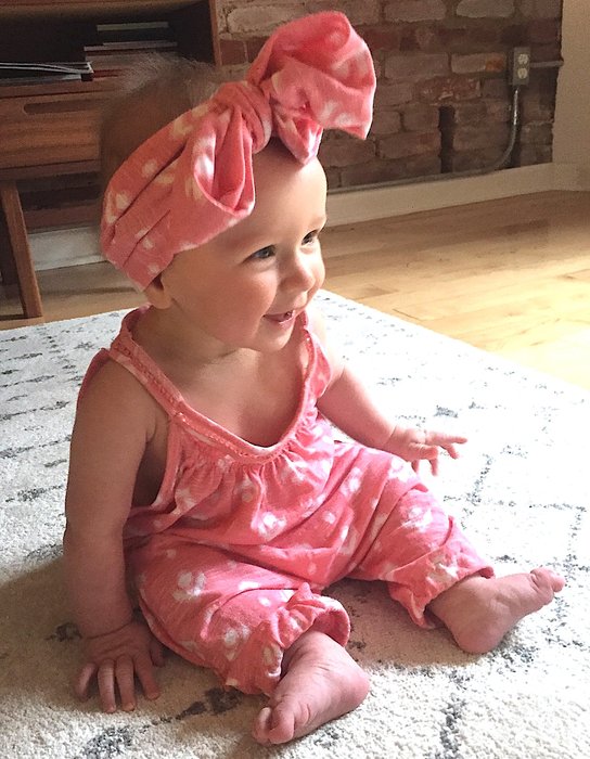 Ariel's infant daughter models the Goodwill tank, which has been upcycled as a romper and headband.