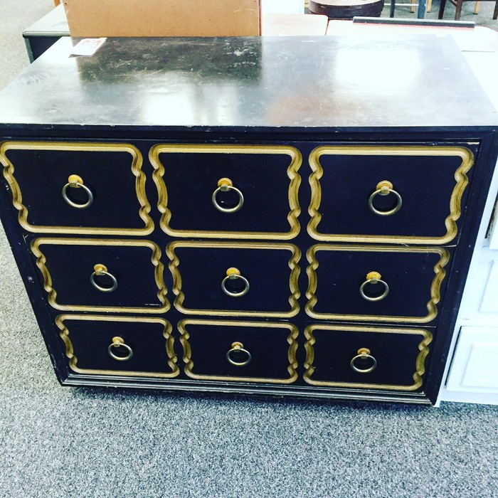 black vintage-look dresser with gold accents found at Goodwill