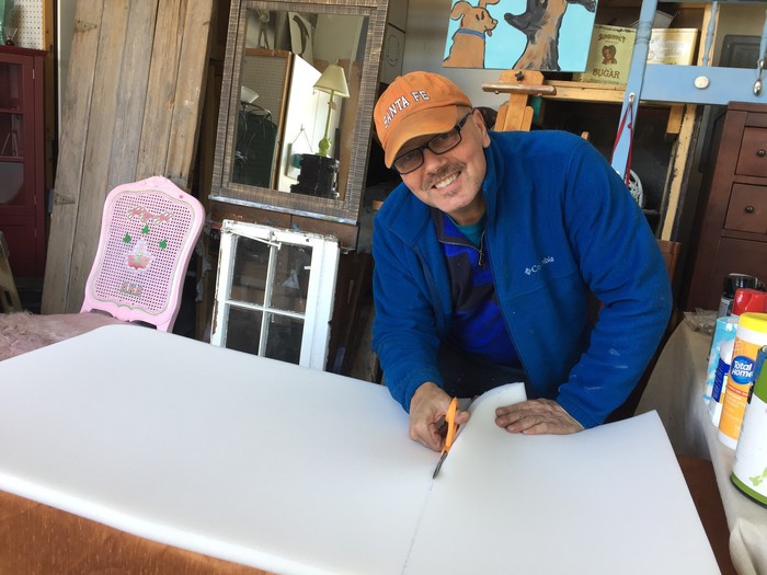 Tim cuts foam padding to act as the mattress of the dog bed