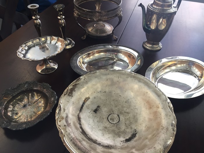 Tim's collection of antique serving trays, platters, and candlestick holders found at a local Goodwill