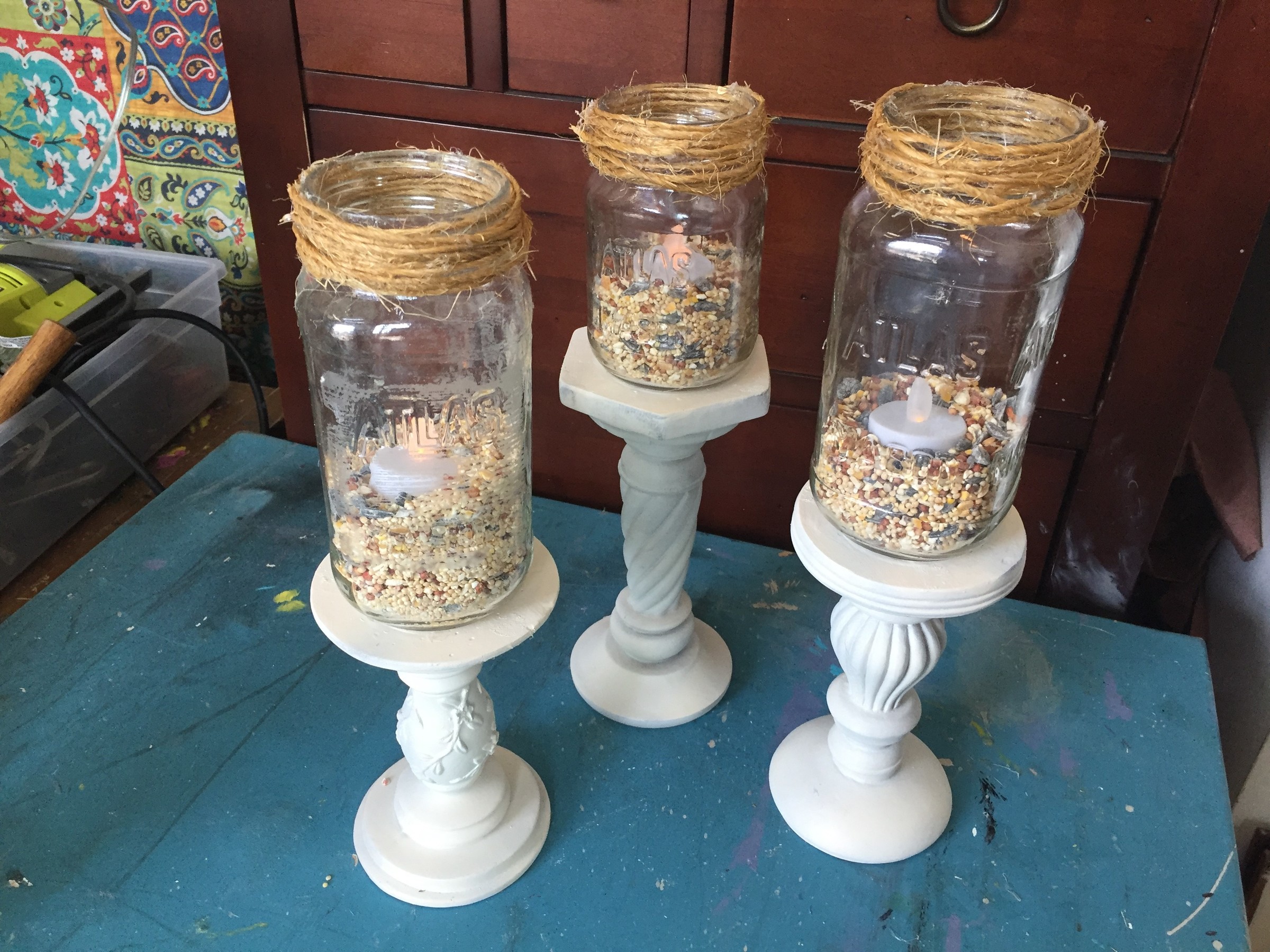 Tim adds bird seed and flame-less candles to mason jars