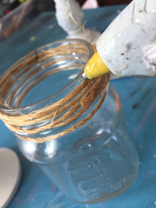 Tim wraps twine around mouth of mason jar and secures with hot glue