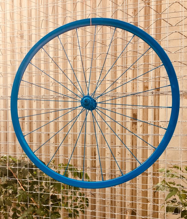 Tim mounts the bicycle wheel using wire.