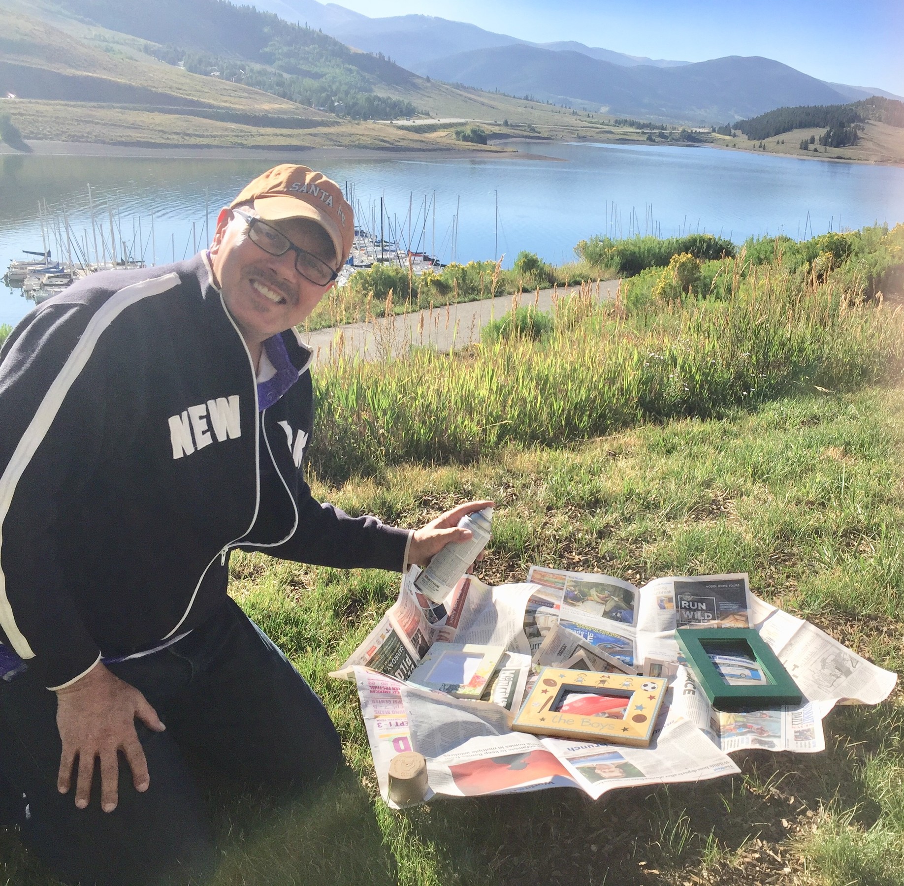 Tim lays several frames on newspaper before spraying with paint