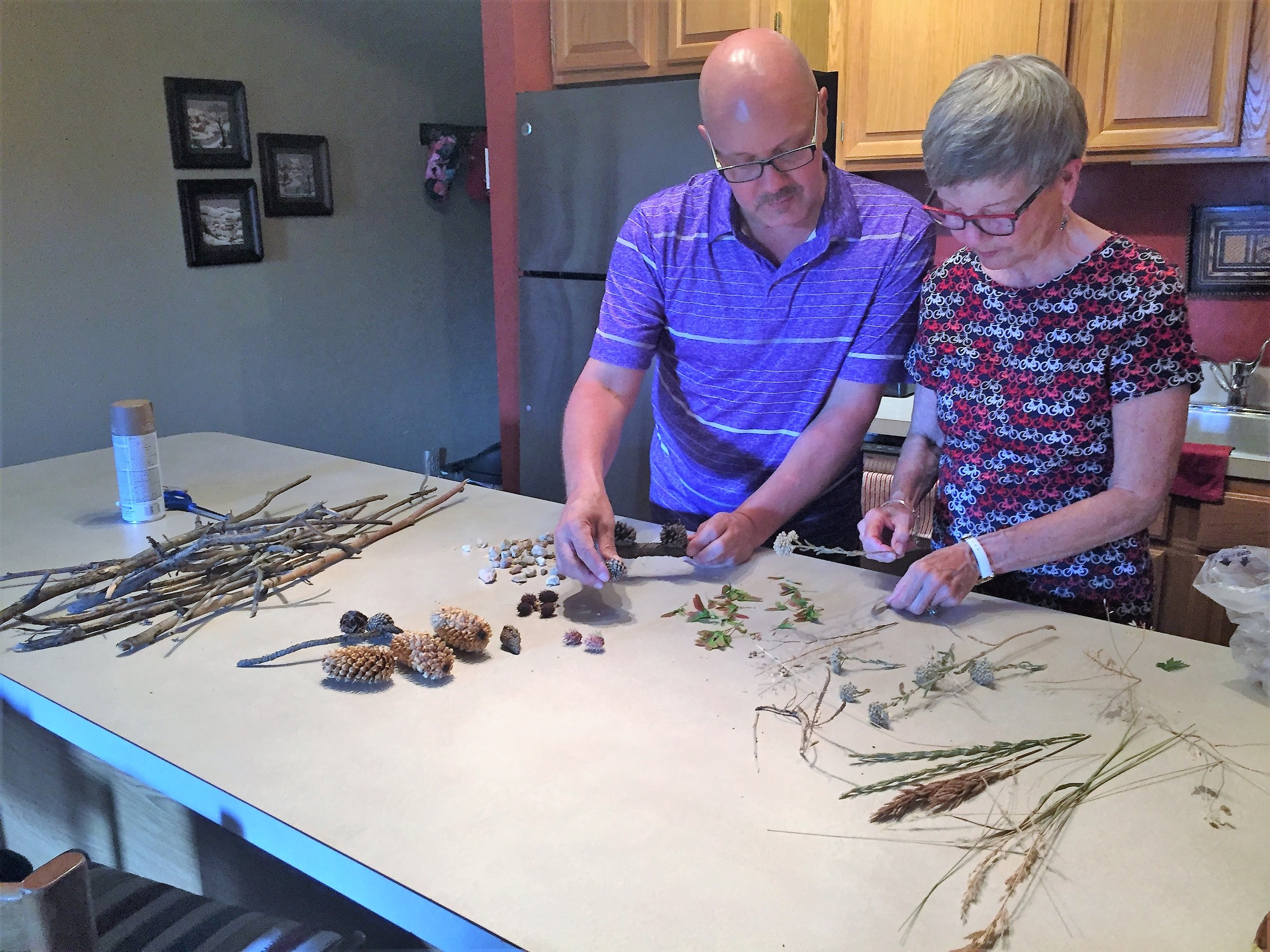 Tim and his Mother sort through natural items used to decorate their frames