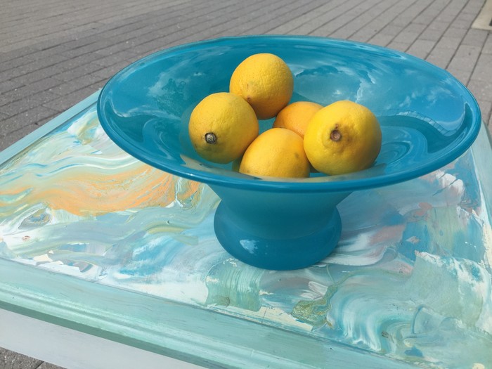 Tim displays a completed photo frame tray and painted sea glass bowl full of lemons