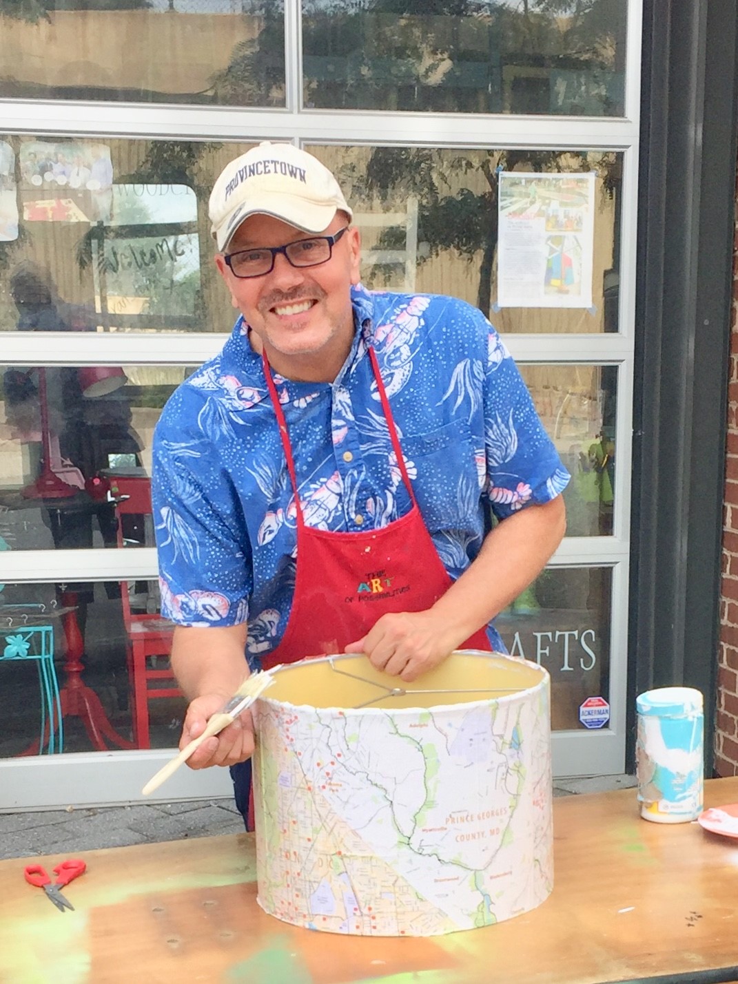 Tim decoupages maps onto a lampshade