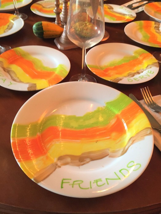 Tim displays a plate with the word "friends" painted under the colorful waves
