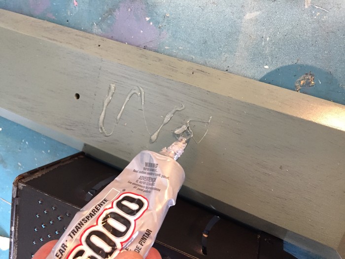 Tim uses E5000 adhesive to attach the grater to the painted wood