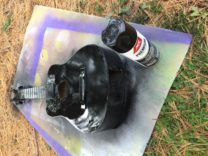 Tim sprays a coat of black paint on the guitar